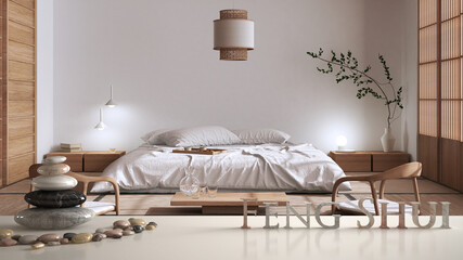 White table shelf with pebble balance and 3d letters making the word feng shui over modern japandi wooden bedroom in contemporary apartment, zen concept interior design