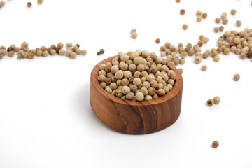 white peppers in wooden bowl isolated on white