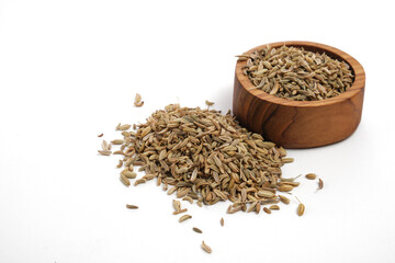 Fennel seeds on wooden saucer isolated white background