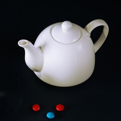 White teapot on a black background.