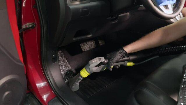 Detailing of a red car. Man cleaning car interior