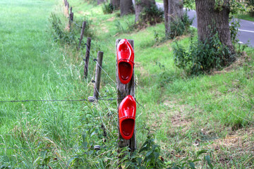 Red clogs on fence at hiking route named clogsroute in Oldebroek