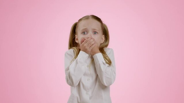 Sudden kid fear. Shocked little girl shouting and covering her mouth in amazement, feeling frightened and afraid