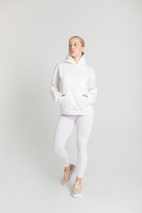 Athletic woman in white hoodie and leggings. Mock-up.