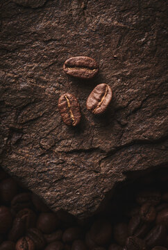 Roasted coffee beans on stone pedestal brown background © amixstudio