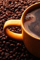 Cup of freshly brewed roasted coffee beans on yellow background