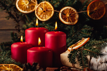 four burning Red advent candles in advent wreath decoration on wooden dark background. tradition in time before Christmas. xmas lights with christmas fir deco background concept. Festive still life.