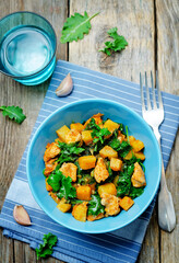 Sweet potato kale chicken stew in a bowl on a wood background