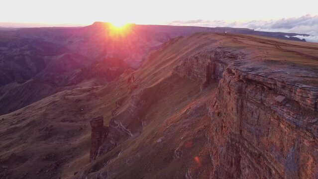 flying along the wall in the mountains at sunset. beautiful view of the rocks in the evening light from a bird's-eye view. caucasus, bermamyt