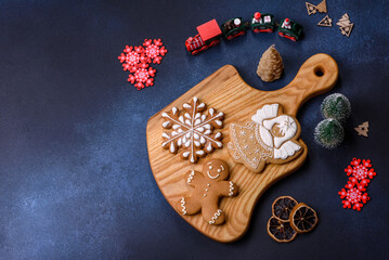 Elements of Christmas decorations, sweets and gingerbread on a wooden cutting board