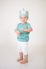 little boy wearing blue clothes and a birthday crown