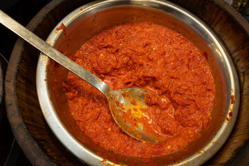 A large vat of harissa in a silver bowl stored in bulk ready to sell smaller measures to consumers...