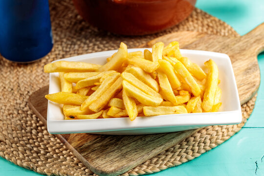 French Fries served in dish isolated on wooden table side view of middle eastern food