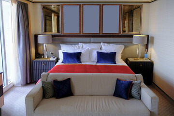 Luxurious ocean view or oceanview or outside balcony veranda cabin stateroom suite queen king double bed on luxury ocean liner cruiseship cruise ship in classic classy interior Art Deco style design