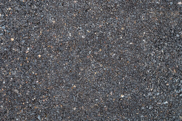 paved road There is a mixture of black, gray, small, and large stones together.