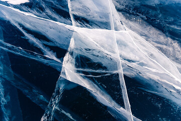 Abstract background texture of blue ice with cracks, top view of winter Lake Baikal