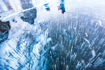 Gas methane bubbles frozen in winter ice of lake Baikal, abstract background