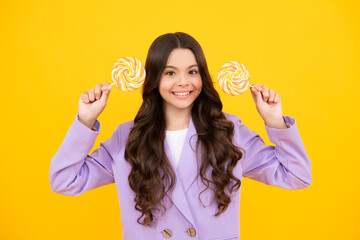 Funny child with lollipop over yellow isolated background. Sweet childhood life. Teen girl with yummy caramel lollipop, candy shop. Happy teenager, positive and smiling emotions of teen girl.