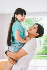 Portrait of young happy asian family spending time together at living room.