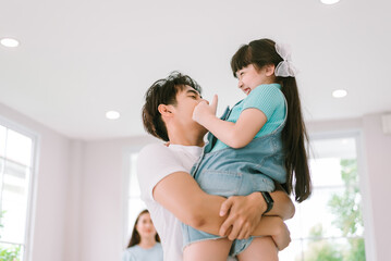 Portrait of young happy asian family spending time together at living room.