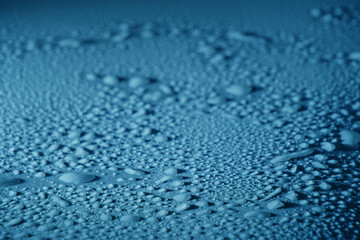 Blue drops of water, dew on smooth surface.