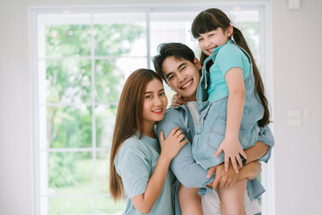 Portrait of young happy asian family spending time together at living room.