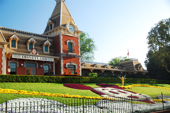 A flower garden is arranged in the likeness of Mickey Mouse in front of the train station that marks the entrance to Disneyland