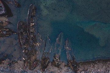 Destroyed wooden pirate ships washed up on the seashore, Aerial top view