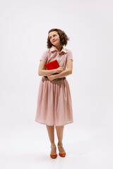 Portrait of cute brunette woman with day makeup posing with book isolated over white background. Dreamy look
