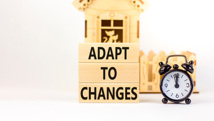 Adapt to changes symbol. Concept words Adapt to changes on wooden blocks. Black alarm clock....