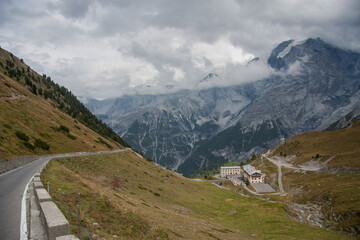 View of the Stelvio pass in Alps with the many turns of it, incredible landscapes and a mountain glacial massif in the background