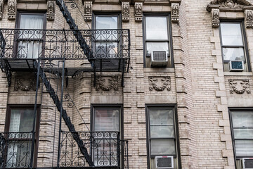 Old New York apartment building with fancy terra cotta detailing Manhattan Lower East Side apartment building with external fire ladders