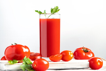 Refreshing tomato juice with herbs on white background. Vegan vegetable drink.
