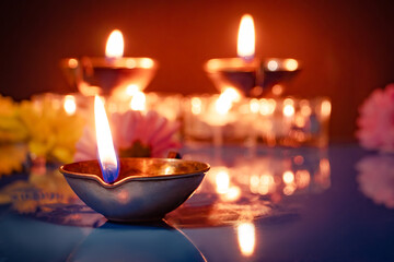 Happy Diwali. Traditional symbols of Indian festival of light. Burning diya oil lamps and flowers...