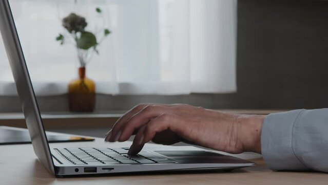 Female hands of mature businesswoman professional user typing on computer keyboard sitting at home office desk chatting emailing to client working online with tech software net apps close up side view
