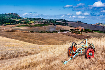 Obraz premium An abandoned hydraulic farm plow in the fields of Tuscany, Italy