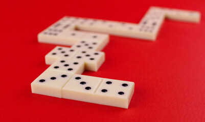 White domino laid out in the shape of a heart on a red background