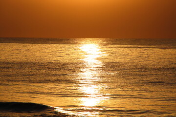 Obraz premium Sunset reflection over the sea on the beach