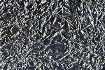 Silver crumpled aluminum foil flat background and texture. Shiny surface.