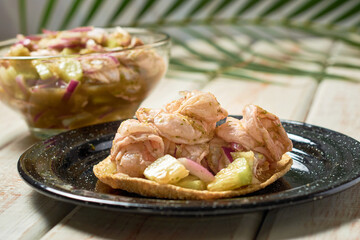 Mexican seafood called aguachile, raw shrimp dipped in lime and green sauce.