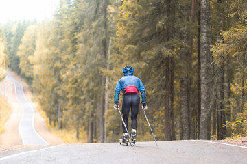 Cross country skilling.A man on roller skis rides in the autumn park.