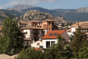 Fototapeta na wymiar Paisaje casas pueblo Manzanares el Real con montañas de la pedriza. Madrid, España