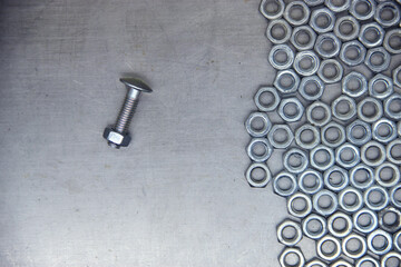 Obraz na płótnie Canvas A set of various nuts, bolts, screws on the background of a steel plate. Locksmith business.