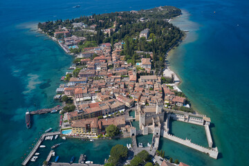 High altitude aerial view of Sirmione, Lake Garda. Top view Town of Sirmione entrance walls view, Lago di Garda, Lombardy region of Italy drone view.