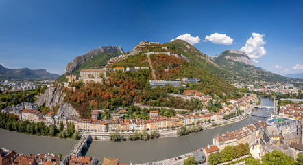 The drone aerial view of hill and fortress of the Bastille. The Bastille located at the south end of the Chartreuse mountain range and overlooking the city of Grenoble, France.  - obrazy, fototapety, plakaty
