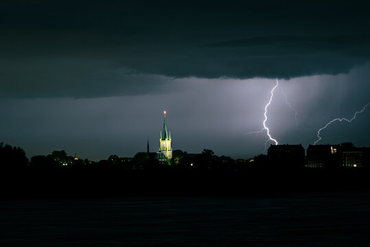 Lightning bolt strikes close to an illuminated church