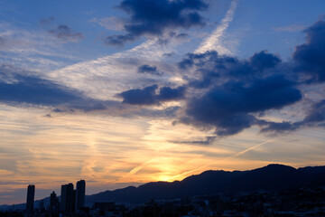 夕暮れ六甲山に陽が沈んだあと、まだオレンジ色の光が残る。神戸市内から六甲の稜線を撮影
