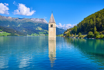 bell tower that comes out of the lake of resia, italy - obrazy, fototapety, plakaty