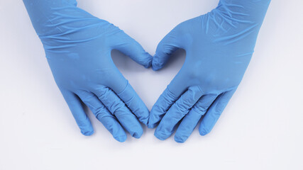 female doctor's hand wearing medical gloves make a heart symbol about health, health insurance,...