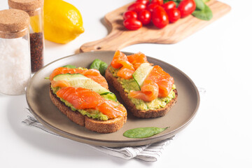 Two tasty open salmon sandwiches with avocado and cucumber. Morning healthy breakfast. Top view.